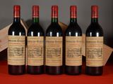 four bottles of wine are lined up on a table