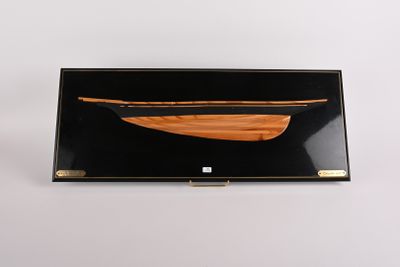 pochette noire et dorée ornée d'un bateau en bois sur le devant