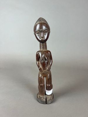 une statue en bois représentant une femme tenant un bébé dans ses bras