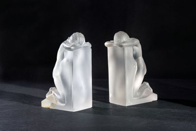 two statues of a man and a woman on a black surface