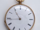 une montre de poche en or avec des chiffres romains sur le cadran