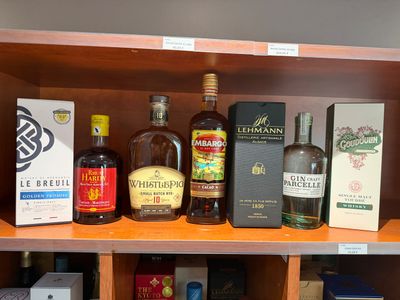 de nombreuses bouteilles d'alcool sur une étagère dans un magasin de spiritueux