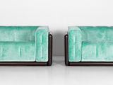 une paire de fauteuils en velours vert, avec des pieds et des accoudoirs noirs