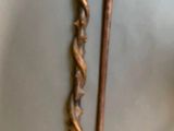 pair of antique wooden canes with metal handles on a white surface
