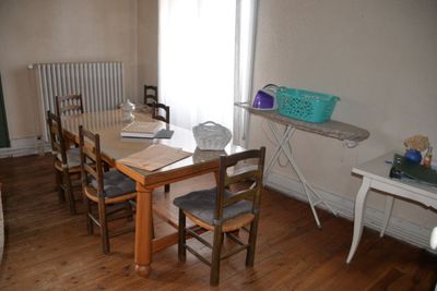 une table et des chaises dans une pièce, avec un radiateur en arrière-plan