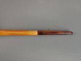 an image of a pipe with a wooden handle on a gray surface