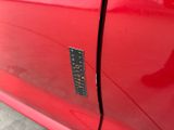 a close up of a red car with a sticker on it