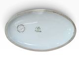 a white plate with a gold rim and a green emblem on it