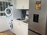 a kitchen with a refrigerator, washing machine, and a washing machine