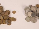 two piles of coins on the table next to each other