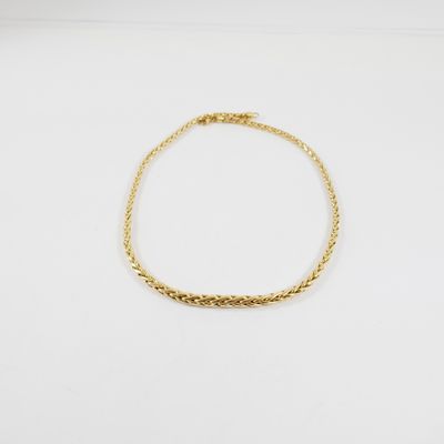 un bracelet en or avec un motif de tresse sur fond blanc