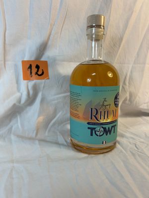 a bottle of rum that is sitting on a bed