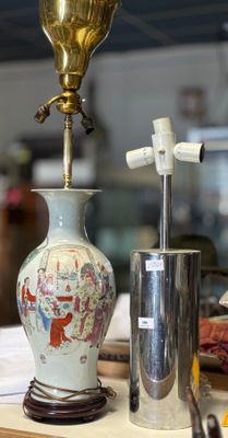un vase posé sur une table, sur laquelle se trouve une lampe