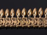 an image of a row of gold bracelets on a black surface