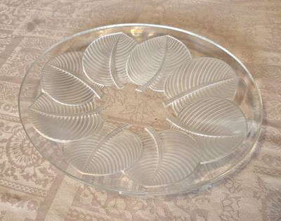 une assiette en verre transparent posée sur une table et ornée d'un motif