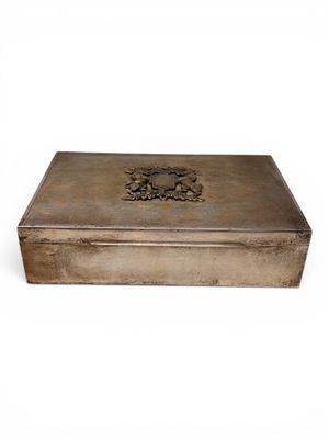 an antique silver box with a design on the lid