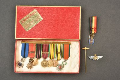 une boîte rouge contenant des médailles et des insignes