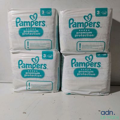 quatre paquets de couches Pampers empilés les uns sur les autres