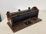 une locomotive à vapeur d'époque posée sur un socle en bois, sur une surface blanche