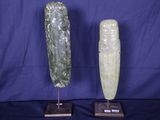 une paire de sculptures en pierre sculptées, posées sur des socles, sur fond bleu