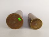 pair of brass vases with green labels on them on a white surface