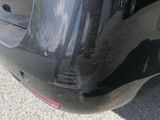 the rear end of a black car with a red tail light