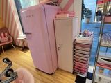 un réfrigérateur rose et une chaise rose dans une pièce