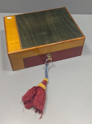 a small wooden box with a tassel hanging from it