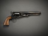 an old revolver with a wooden handle on a gray background