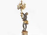 an antique bronze figurine of a boy holding a chandelier