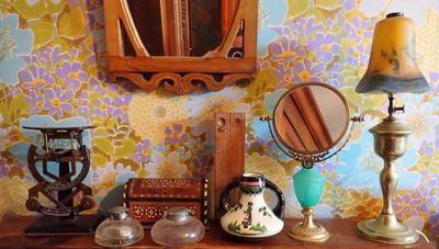 une table sur laquelle se trouvent un miroir, une lampe, un miroir et d'autres objets