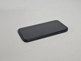 the back of a black cell phone sitting on top of a white table