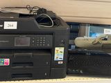 une imprimante et un ordinateur portable posés sur une étagère dans un magasin