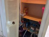 a closet in the corner of a room with a door open