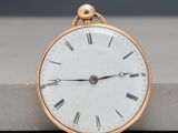 a gold pocket watch with roman numerals on it