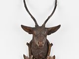 une image représentant une tête de cerf accrochée à un mur blanc