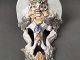 une plaque murale blanche et orange sur laquelle figure un lion