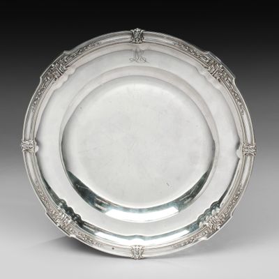 une assiette en argent antique avec un motif décoratif sur le bord