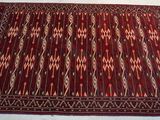 un tapis rouge posé sur un lit recouvert d'une couette blanche