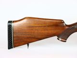 a close up of a rifle on a white surface with a white background