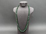 un collier de perles vertes sur un mannequin d'exposition
