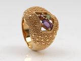 an image of a gold ring with purple and green stones