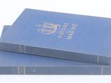 deux livres bleus posés l'un sur l'autre sur une surface blanche