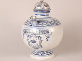a blue and white vase with a lid on a table