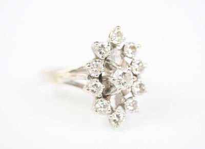 a close up of a diamond cluster ring on a white background