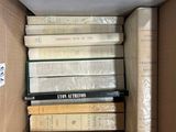 a box full of books that are stacked on top of each other