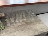 bottles and glasses on a counter in a kitchen with a refrigerator