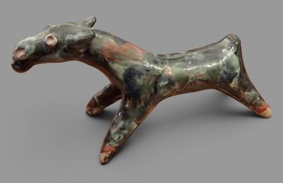 sculpture of a horse made of clay on a gray surface
