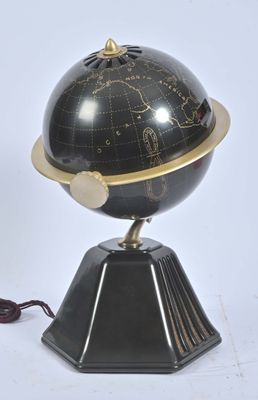 une image représentant un globe terrestre noir et doré posé sur un socle