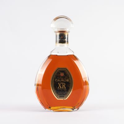 une photo d'une bouteille de brandy posée sur une surface blanche